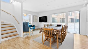 A spacious living area with a dining table, chairs, a TV, and a staircase. - Awesome home in Nivå with WiFi (Nivå)