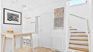 A modern, minimalist room with a wooden staircase, a radiator, and a wall-mounted tapestry. - Awesome home in Nivå with WiFi (Nivå)