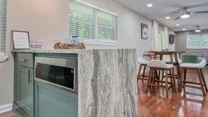 A kitchen with a marble countertop, wooden chairs, and a dining table. - Atlanta's East Point charm, just a 13-min drive away from Mercedes-Benz Stadium (East Point)