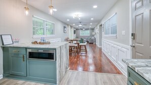 A kitchen with a marble countertop, wooden cabinets, and a built-in oven. - Atlanta's East Point charm, just a 13-min drive away from Mercedes-Benz Stadium (East Point)