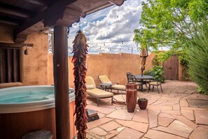 A patio with a hot tub, lounge chairs, and a table with chairs. - Casa Lobo - Wild Relaxation - Private Hot Tub (El Prado)