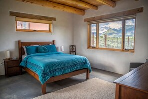 A bedroom with a wooden bed, a nightstand, a bedside table, a window with a mountain view, and a wooden ceiling. - Casa Lobo - Wild Relaxation - Private Hot Tub (El Prado)