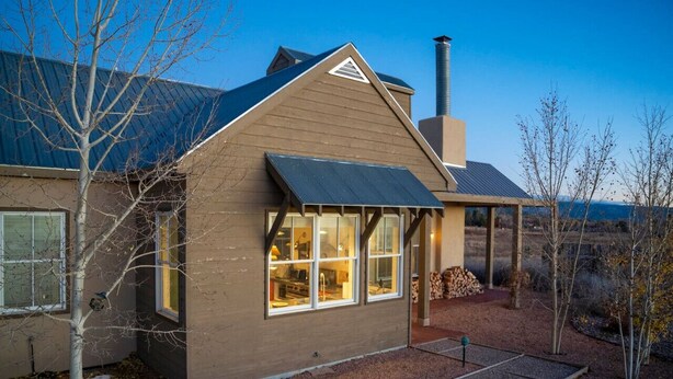 Une maison avec un toit en pente, une cheminée et une fenêtre donnant sur un beau paysage.