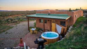 A rustic house with a hot tub, outdoor seating, and a gravel patio. - Casita de Alfarero -  A Peaceful Escape - New Hot Tub! (El Prado)