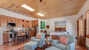 Amplia sala de estar con cocina, comedor y un dormitorio.