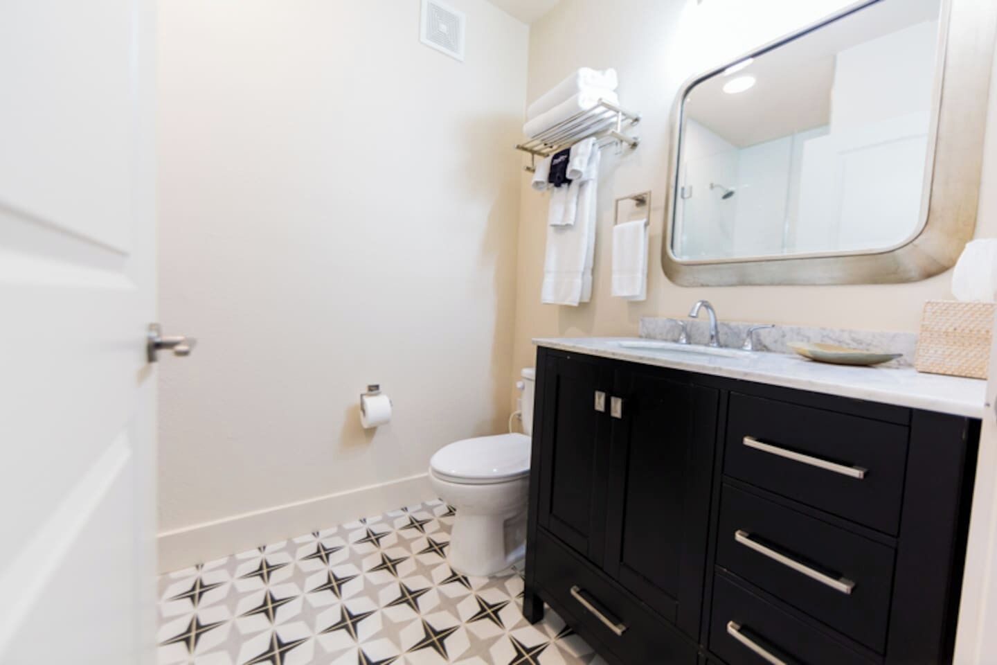 Een badkamer met toilet, een wastafel met spiegel erboven en een douchegedeelte.