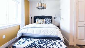 Une chambre à coucher avec un lit, un lustre et un tapis à motifs.