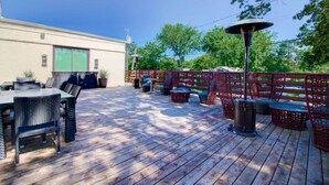 A wooden deck with outdoor furniture, a barbecue grill, and a covered seating area. - Comfort Studios, 1 Queen(Mumbai) (Dallas)