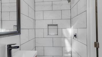 Comfort studio | Badkamer | Een douche, een haardroger, handdoeken, zeep