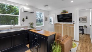 Una cocina moderna con un amplio ventanal, un lavamanos integrado y una isla de madera.
