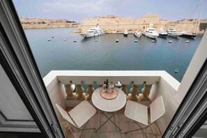 A balcony with a table and chairs overlooking a marina with yachts. - Harbour view 2 bedroom apartment overlooking harbour (Senglea)