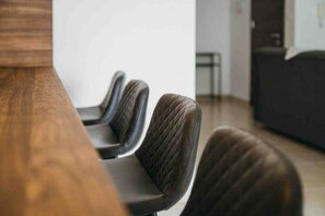 Un salón de conferencias con una larga mesa y cuatro sillas.