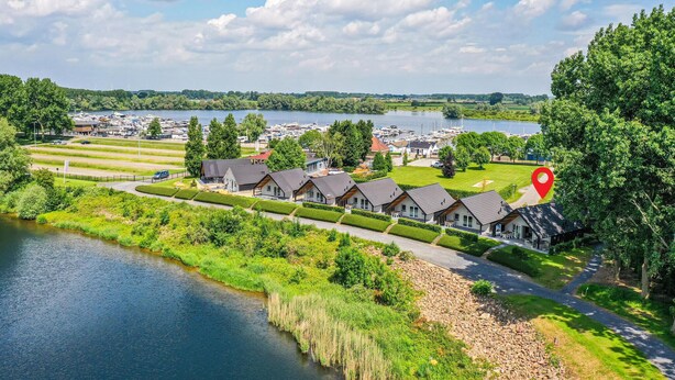 Un quartier résidentiel au bord d’un lac, avec des maisons, un port de plaisance et une rivière.