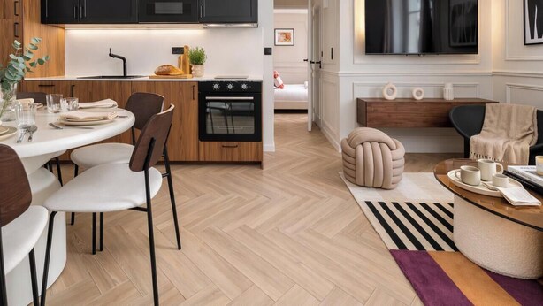 Una cocina moderna con comedor, sofá y televisor.