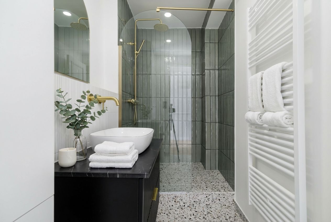 Une salle de bain moderne avec une douche à parois de verre, un lavabo blanc et un porte-serviettes.