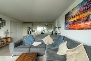 Relax in this stylish living space with a comfortable sofa and modern kitchen area.