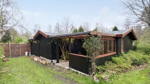 A wooden house with a porch and a fenced yard. - Beautiful home in Vejby with kitchen (Vejby)