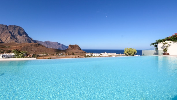 A clear blue pool with a mountain backdrop and a view of the sea. - Paraisos de Agaete Penthouse Views (El Turman)