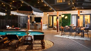 A pool area with lounge chairs, a bar, and a dining setup. - Valrico Villa: Pool, Spa, Court & Game Room (Valrico)
