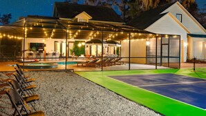 A house with a swimming pool, outdoor seating, and string lights. - Valrico Villa: Pool, Spa, Court & Game Room (Valrico)
