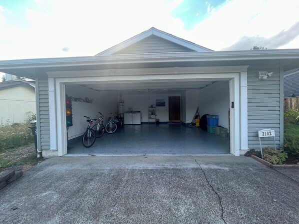 Two bicycles are parked in this garage with a utility room and storage.