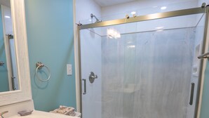 Une salle de bain équipée d’un lavabo, de toilettes et d’une douche à parois de verre.