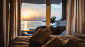 A bed with a view of the sea at sunset, a plant, and a chair. - Pet friendly home in Razanj (Razanj)
