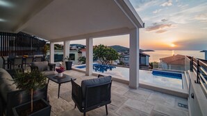 A covered outdoor area with a pool, seating, and a view of the sea at sunset. - Pet friendly home in Razanj (Razanj)
