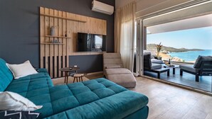A modern bedroom with a large bed, a TV, a small table, and a view of the sea. - Pet friendly home in Razanj (Razanj)
