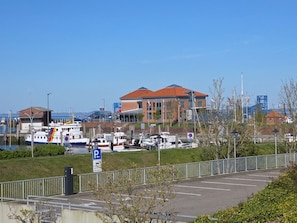 A marina with boats, a building with a red roof, and a parking area. - Haus Ekke Nekkepenn I, Whg. 6 - Haus Ekke Nekkepenn I, (Wyk auf Föhr)