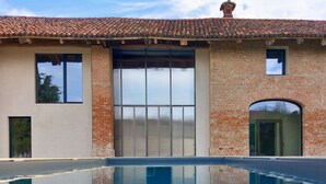 Un bâtiment doté d’une piscine, de grandes fenêtres et d’une façade en briques.