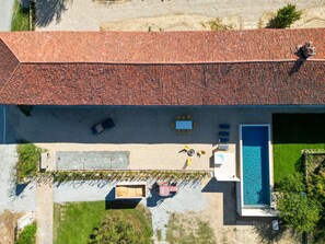 An aerial view of a property with a swimming pool, outdoor seating, and a red-tiled roof. - We Rural by Interhome (Poirino)