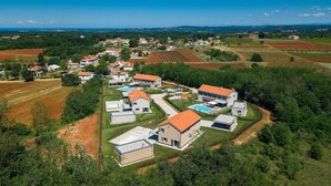 Zona residencial con casas, piscina y viñedos.