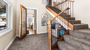 Una escalera con barandas de madera y escalones alfombrados que sube a un nivel superior.