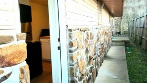A stone wall with a wooden deck and a stone staircase leading to a covered area. - Magnolia #3 @ Copper Johns Resort (Lakeview)