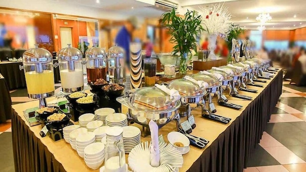 A buffet setup with various food stations, including a fruit punch dispenser, a salad bar, and a hot food station. - Happy Hotel Apartment (Cam Ly - Da Lat)