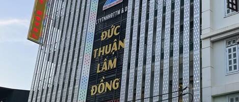 A building with a large sign reading "HAPPY HOTEL" and "CHO PHUONG 6".