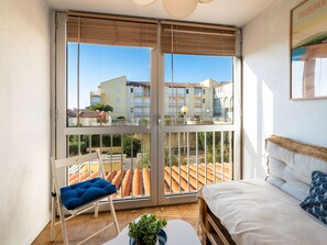 Relax in a serene room with an outdoor space, featuring a comfortable bed, a small table, and a cozy chair.