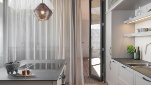 A modern kitchen with a large island, stainless steel appliances, and a view through a glass door. - Stunning home in Vodnjan with sauna (Vodnjan)