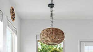 A dining area with a round table, six chairs, and a woven pendant light.