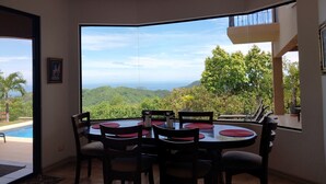A dining area with a view of a mountainous landscape and a pool. - Housekeeping•BBQ•Pool•4 TVs•Garden•Oceanview villa: Casa Sol Azul (Potrero)