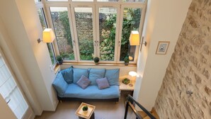 A cozy room with a blue sofa, two armchairs, a small table with a plant, and a staircase. - Villa Campo Bello by Interhome (Dinard)