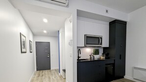 A modern kitchen with a microwave, kettle, and sink. - Modern Loft - Downtown Québec City (Québec)