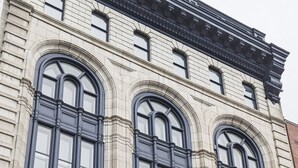 A building with three large arched windows and a stone facade. - Modern Loft - Downtown Québec City (Québec)