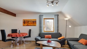 Ein modernes Wohnzimmer mit Esstisch, zwei Sofas, einem Couchtisch und einem Bild an der Wand.