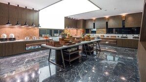 Een moderne keuken met een centraal eiland, houten kastjes en een groot dakraam.