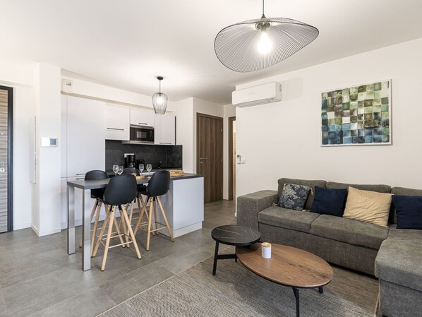 Um apartamento moderno com cozinha, sala de jantar e sala de estar.