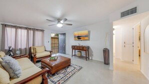 A living room with a sofa, coffee table, and a ceiling fan. - Cozy / Spotless / Central / Remodeled / 2 BR 1 BA (Tucson)