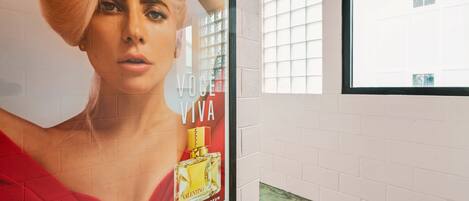 A framed advertisement for a perfume on a wall.