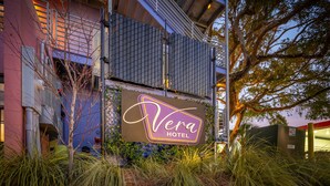 Un letrero de hotel con el nombre "Vera Hotel" y una escalera que conduce a un nivel superior.
